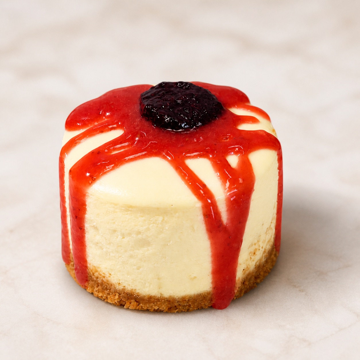 Personal-sized cheesecake with strawberry and blueberry topping