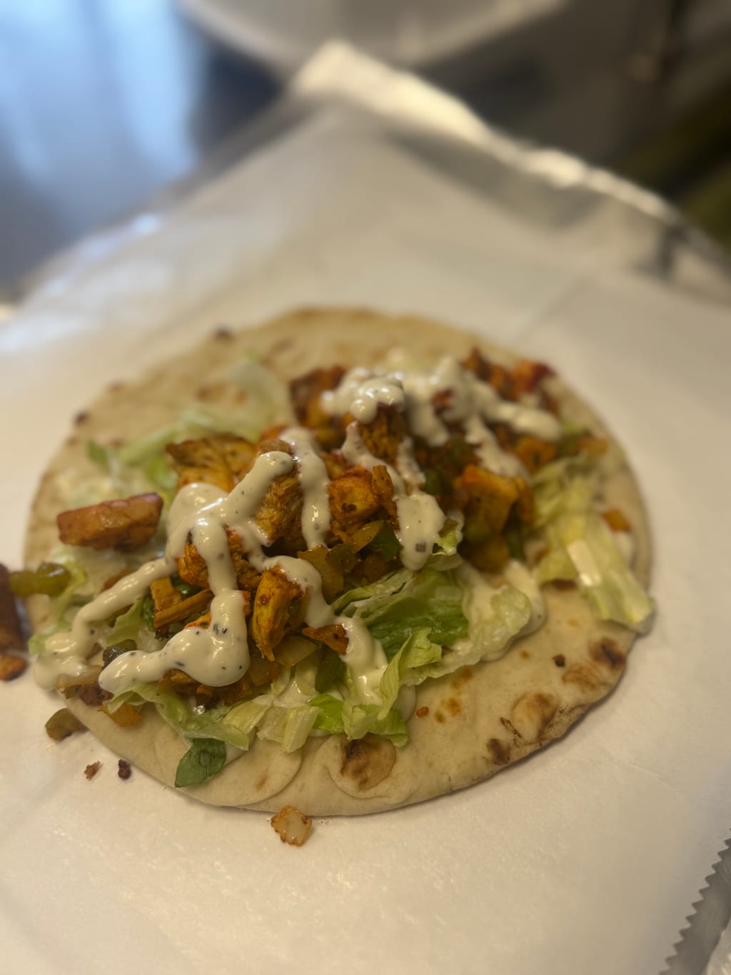Chicken gyro on pita with lettuce and white sauce