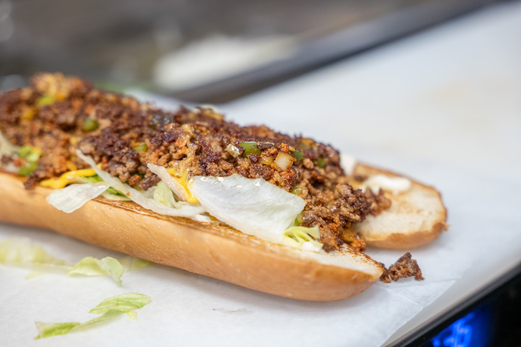 The Famous Chopped: chopped burger with grilled peppers, onion, American cheese and lettuce on a long roll
