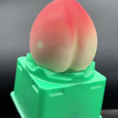 Peach shaped ice cream resting on a bright green base